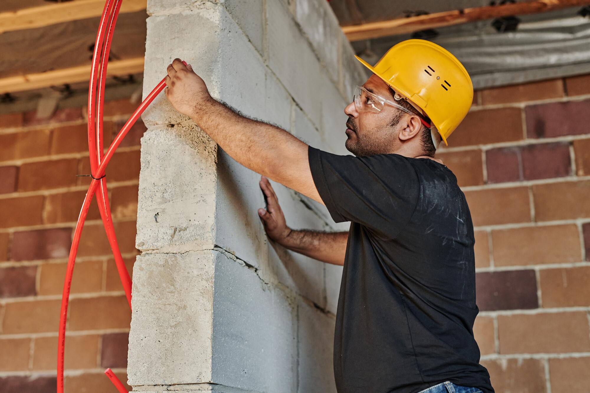 Ouvrier passant un câble dans un mur